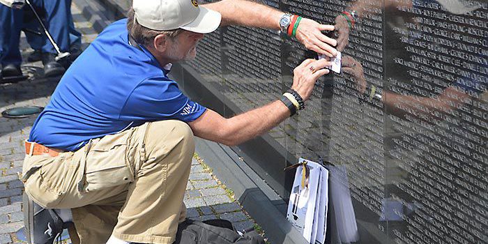 Vietnam veteran Allen Courser of West Point copies one of the names of a fallen soldier engraved on the Vietnam War Memorial in Washington, D.C., on a piece of paper. Courser served in the U.S. Army and was one of many northeast Nebraskans on the Norfolk Iron and Metal plane as a part of a May honor flight for Vietnam veterans.